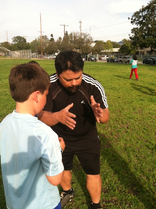 Coach Ray instructs my son, Hosea, on soccer attacking.